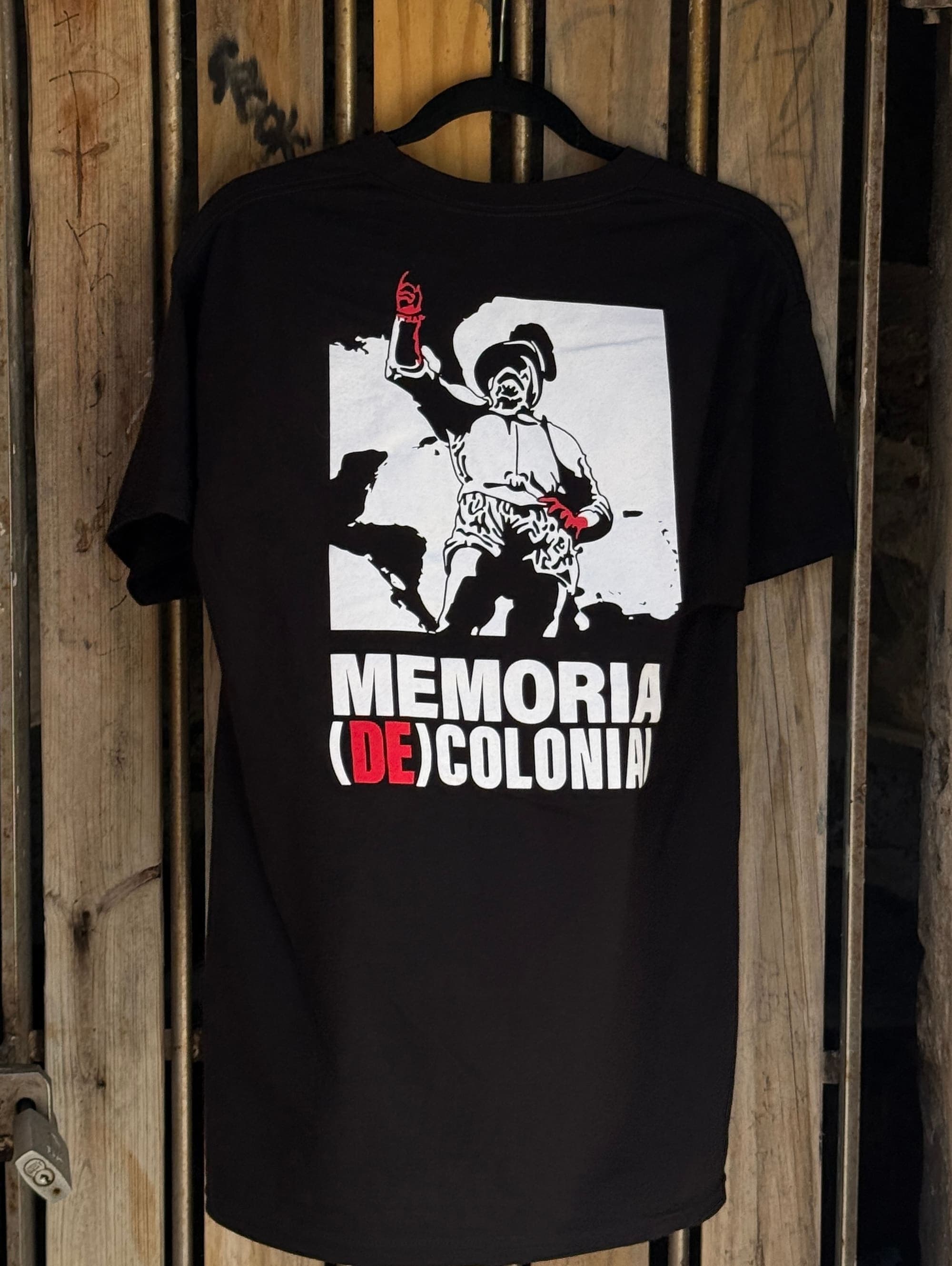 T-shirt negra con el logo de Memoria (De)colonial